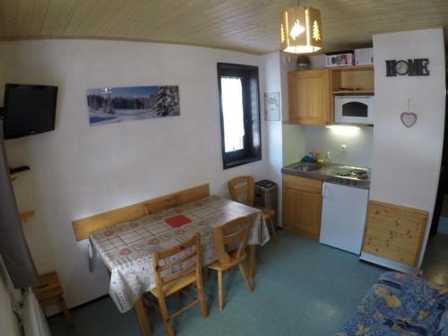 une petite cuisine avec une table et une table et des chaises dans l'établissement Studio 4 pers avec balcon à 600m des remontées mécaniques, parking et animaux admis - FR-1-676-81, à Châtel
