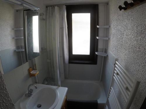 La salle de bains est pourvue d'un lavabo, d'une baignoire et d'une fenêtre. dans l'établissement Studio 4 pers avec balcon à 600m des remontées mécaniques, parking et animaux admis - FR-1-676-81, à Châtel