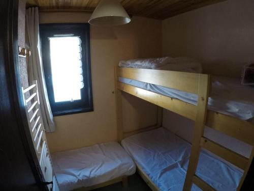 une petite chambre avec deux lits superposés et une fenêtre dans l'établissement Studio 4 pers avec balcon à 600m des remontées mécaniques, parking et animaux admis - FR-1-676-81, à Châtel