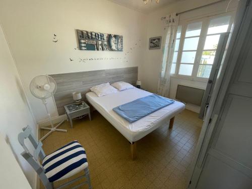 une chambre avec un lit, une chaise et une fenêtre dans l'établissement Maison de vacances à 900m de la plage avec terrasses, parking, et cuisine équipée - FR-1-22-367, à La Tranche-sur-Mer