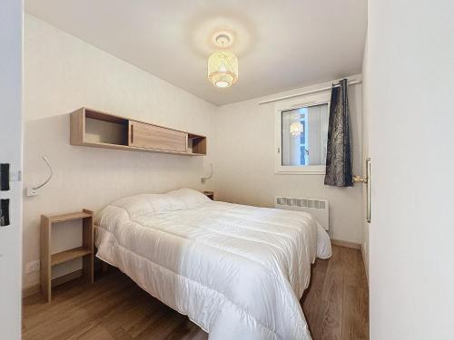 une petite chambre avec un lit blanc et une fenêtre dans l'établissement Appartement à Courseulles-sur-Mer, à 2 min de la plage, balcon sud, parking, tout équipé - FR-1-746-23, à Courseulles-sur-Mer