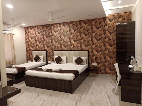 1 dormitorio con 2 camas y pared de madera en Veeras Residency, en Pondicherry