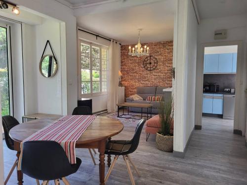 une salle à manger et un salon avec une table et des chaises dans l'établissement Maison confort, 3 chambres, plage à 2 pas, jardin privé sans vis-à-vis, équipements modernes. - FR-1-788-12, à Merville-Franceville-Plage