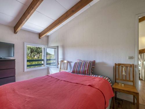 une chambre avec un lit avec une couette rouge et une fenêtre dans l'établissement Maison 2 pièces avec mezzanine proche plage, 6 couchages, Dolus-d'Oléron, calme et WIFI inclus - FR-1-246A-303, à Dolus-d'Oléron