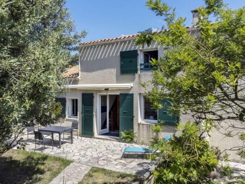 une maison avec une table de pique-nique devant elle dans l'établissement Maison 2 pièces avec mezzanine proche plage, 6 couchages, Dolus-d'Oléron, calme et WIFI inclus - FR-1-246A-303, à Dolus-d'Oléron