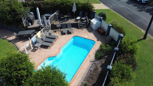 an overhead view of a swimming pool with chairs and umbrellas at BlueWater Apartments in Merimbula