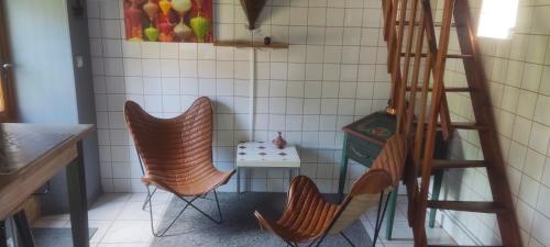 deux chaises dans une petite cuisine avec une échelle dans l'établissement La Chaume de Condé, à La Celle-Condé