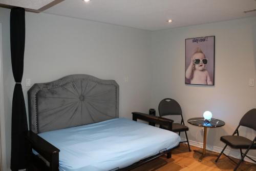 1 dormitorio con 1 cama, mesa y sillas en Your Own Suite-Modern Charm Hideaway Near Tor Airpt, en Brampton