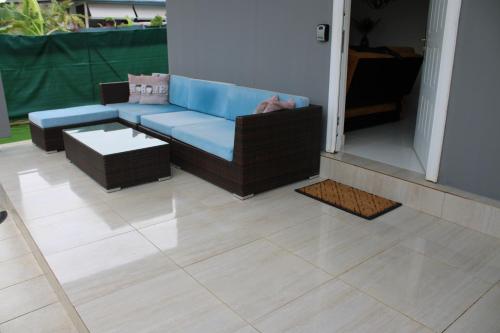 a living room with a blue couch on a tile floor at L'Awara - paisible et chaleureux in Cabassou