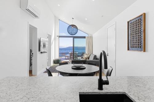 a living room with a table and a couch at Absolute Lakefront House in Taupo