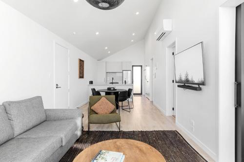 a living room with a couch and a table at Absolute Lakefront House in Taupo