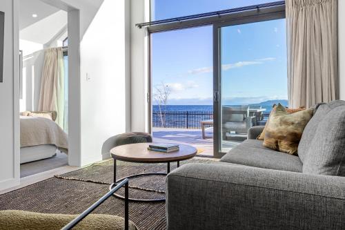 a living room with a couch and a view of the ocean at Absolute Lakefront House in Taupo