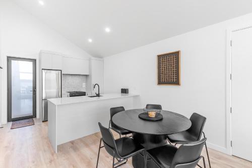a kitchen and dining room with a table and chairs at Absolute Lakefront House in Taupo
