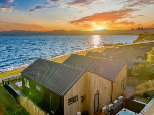 an aerial view of a house on the water at sunset at Absolute Lakefront House in Taupo
