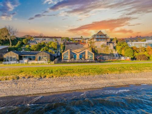 a view of a resort from the beach at sunset at Absolute Lakefront House in Taupo