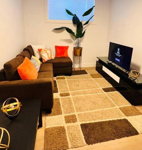 a living room with a couch and a tv in it at B19 Modern Stylish 2bed Basement Suite in Edmonton