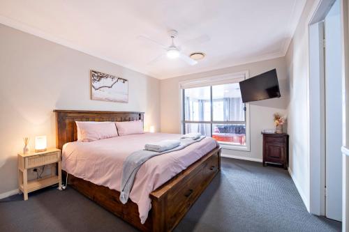 a bedroom with a large bed and a window at Mason's Lodge - Family Entertainer, Close to Mall in Dubbo