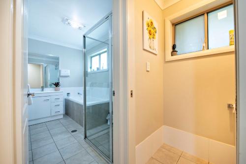 a bathroom with a shower and a glass shower stall at Mason's Lodge - Family Entertainer, Close to Mall in Dubbo
