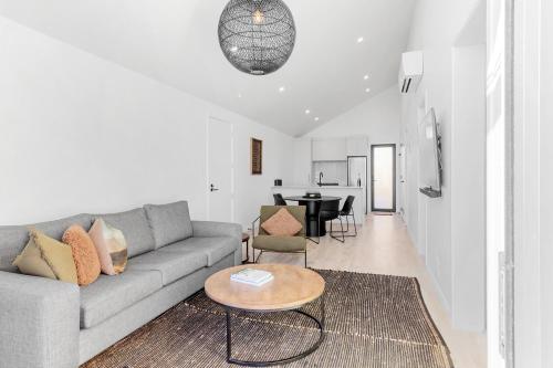 a living room with a couch and a table at Brand New Lake Front homes Spa Pool in Taupo