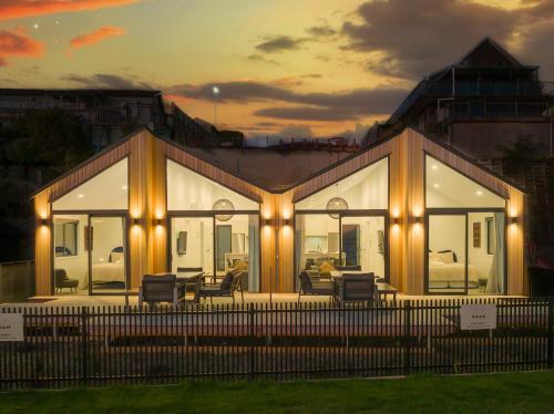 a house with windows and chairs in front of it at Brand New Lake Front homes Spa Pool in Taupo