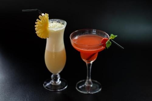 two cocktails sitting next to each other on a table at d'kamala by Prasi in Ubud