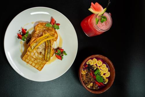 a white plate with food and a drink on a table at d'kamala by Prasi in Ubud