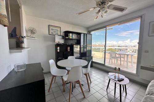 une cuisine et un salon avec une table et des chaises dans l'établissement LE MATHILDE - Appart 1 chambre Vue dégagée proche de la plage avec parking, au Grau-du-Roi