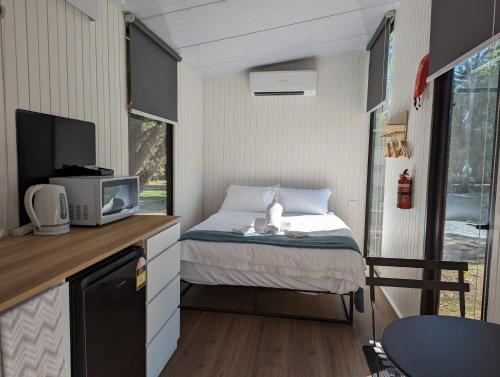 ein kleines Schlafzimmer mit einem Bett in einem winzigen Haus in der Unterkunft Tiny House 5 at Grampians Edge in Dadswells Bridge