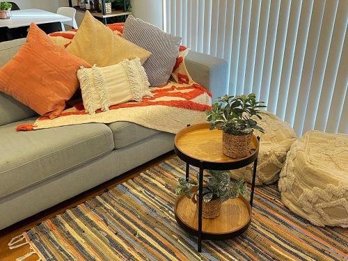 a living room with a couch with pillows and a table at Flat Bush Holiday Accomodation in Auckland