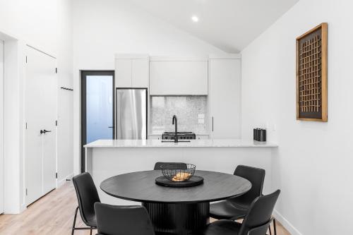 a kitchen and dining room with a table and chairs at Premium Lakefront Unit Spa Pool in Taupo