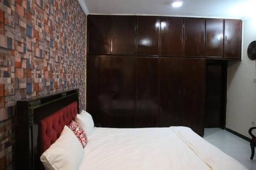 a bed in a room with a brick wall at 6 bedrooms Villa in DHA in Lahore