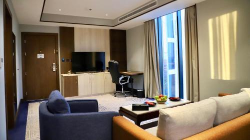 een woonkamer met een bank en een tv bij Five Seasons Hotel in Tabuk