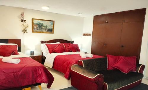 um quarto de hotel com duas camas e um sofá em La Candelaria Centro Histórico - Cozy Room Bogotá em Bogotá