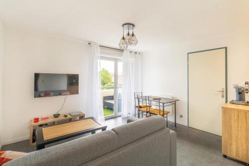 un salon avec un canapé et une table dans l'établissement Cosy apartment with pool, à Toulouse
