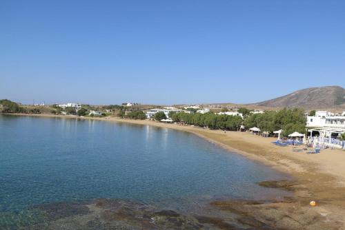 a view of a beach with chairs and buildings at Oasis Studios Logaras in Logaras