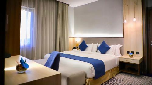 a hotel room with a large bed with blue accents at Five Seasons Hotel in Tabuk