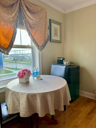 a table in a room with a window and a table with flowers at Inn on the Harbour in Charlottetown