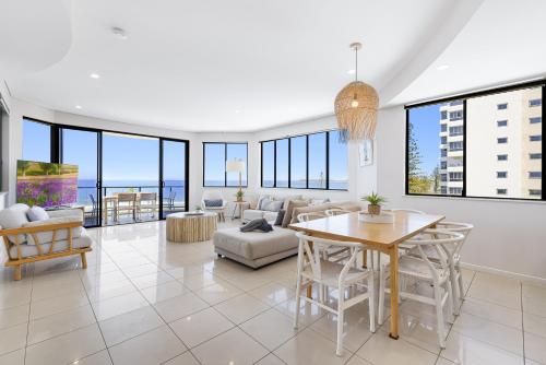 een woonkamer met een tafel en stoelen bij Meridian Alex Beach Apartments in Alexandra Headland