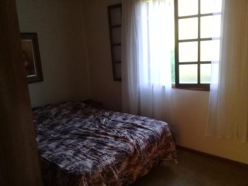 帕薩誇特魯的住宿－Casa Familiar，卧室在窗户前配有一张床
