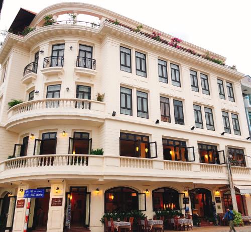 a large white building with a balcony on a street at Nam Bo Boutique Hotel in Can Tho