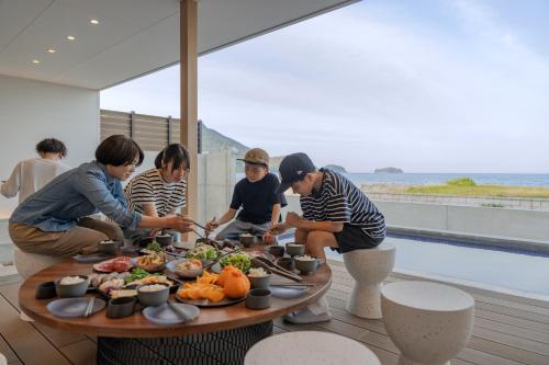 a group of people standing around a table with food at SETO CLAS TSUDA THE BEACH RESORT C in Yoshimi