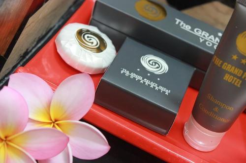 a red tray with some products and flowers on it at The Grand Palace Hotel Yogyakarta in Yogyakarta