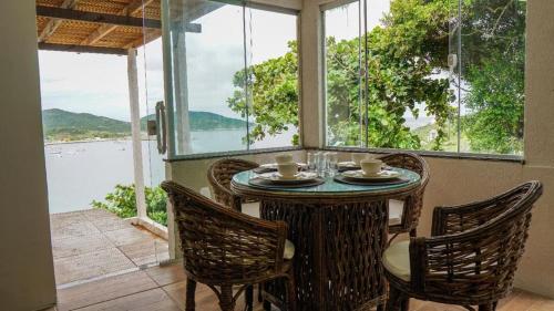 a table in a room with a view of the water at Pousada do Mirante do Atalaia in Arraial do Cabo