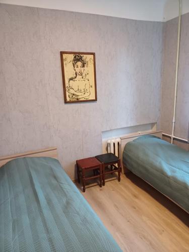 1 dormitorio con 2 camas, mesa y una foto en Green Oaks Private Rooms with Private Shower en Klaipėda