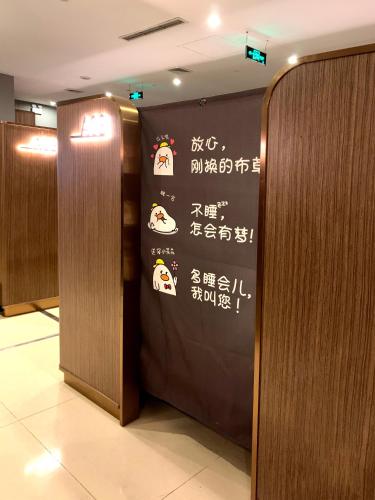 Chengdu Airport Take A Nap Capsule Hotel（T2） في تشنغدو: علامة على جدار في المصعد