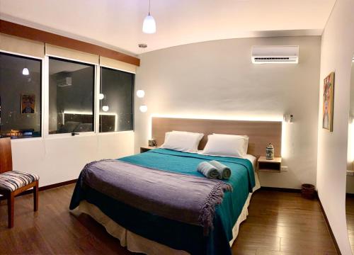 sypialnia z dużym łóżkiem i niebieskim kocem w obiekcie Ciprés Confort w mieście Santa Cruz de la Sierra