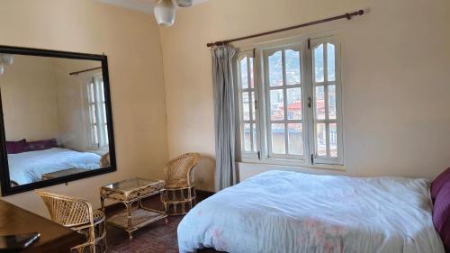 Bodhi Homestay في كاتماندو: غرفة نوم بسرير ومرآة كبيرة