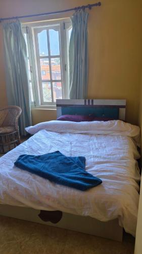 a bed with two blue towels on top of it at Bodhi Homestay in Kathmandu
