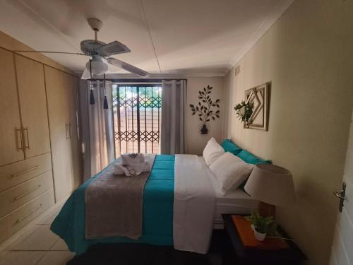 a bedroom with a bed with a cat sitting on it at Sea La Vie in Richards Bay