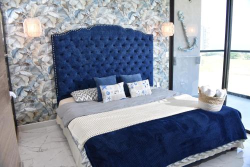 a bedroom with a blue bed with pillows at Lujoso apto con vista al mar, en salinas del mar in Playa Dormida